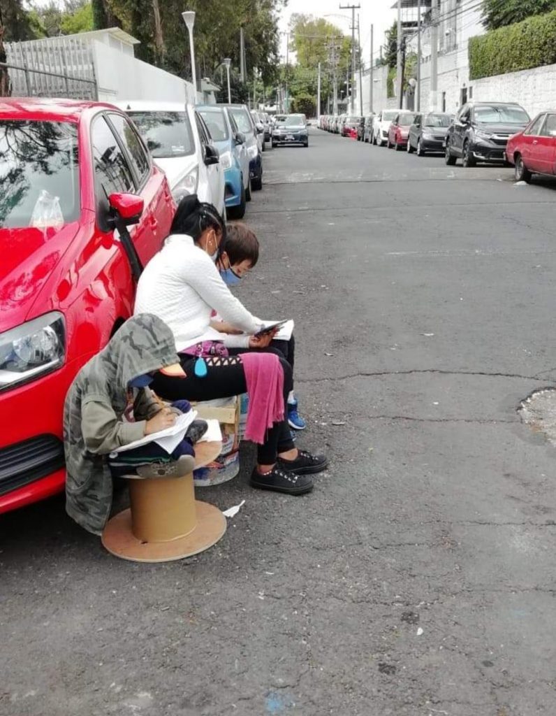 Conmueve en redes sociales madre que enseña a sus hijos a estudiar en la calle