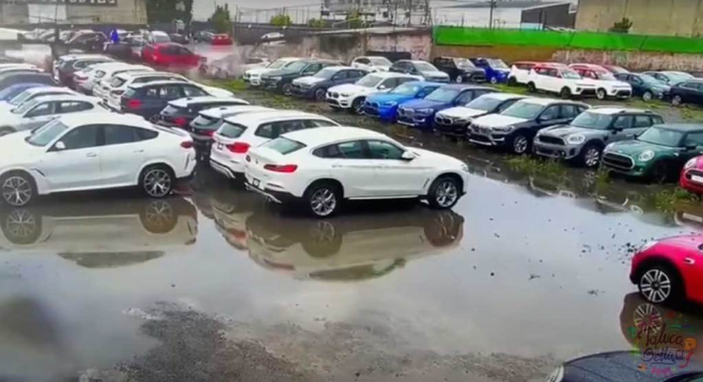 metepec noticias del momento en que colapsó la barda de la iglesia que terminó afectando unidades de lujo de una agencia de automoviles.
