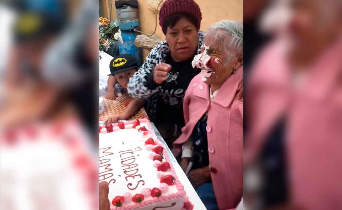 Abuelita es empujada a pastel y se ríe.