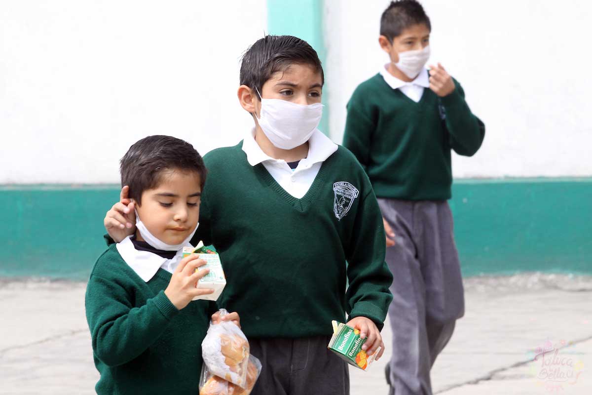 Niños usando cubrebocas dentro de las aulas de clase
